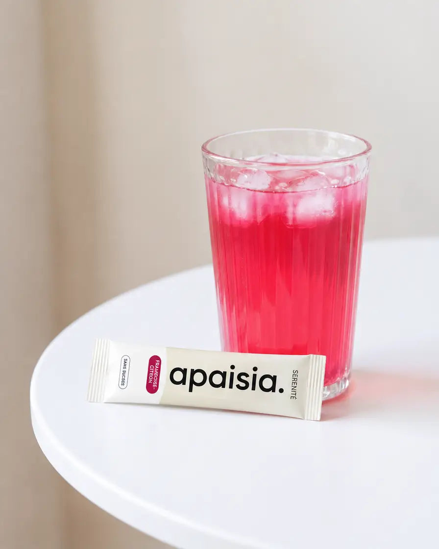 Un stick Apaisia posé à côté d'un verre framboise-citron glacé
